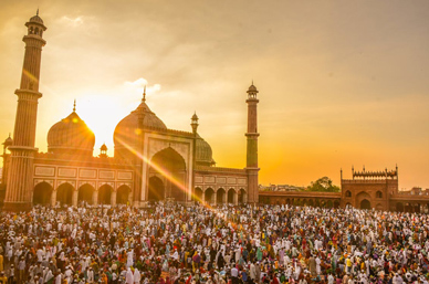 Crowd gathered for Eid al-Fitr prayer at sunset, symbolizing unity and holiday travel with Ethiopian Airlines.