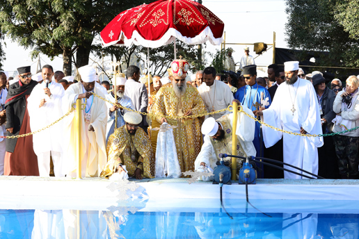 Priests in golden robes performing the Timket water blessing ceremony beside a pool during Ethiopia’s Epiphany.