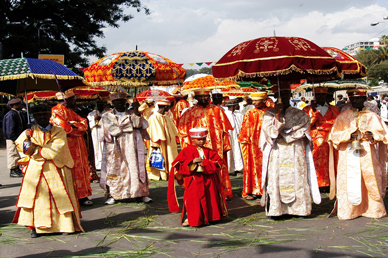 Ethiopian Orthodox clergy in vibrant ceremonial robes and decorated umbrellas celebrating the Timket Epiphany festival.