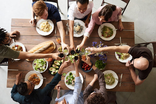 Group raising glasses for a cheerful Thanksgiving toast, sharing food, friendship, and holiday celebration.
