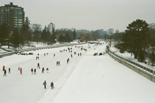 People skating on a frozen Canadian canal in winter, highlighting scenic adventures for Ethiopian Airlines travelers.