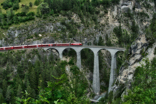Iconic red train crossing Switzerland’s Landwasser Viaduct on a scenic summer journey with Ethiopian Airlines.